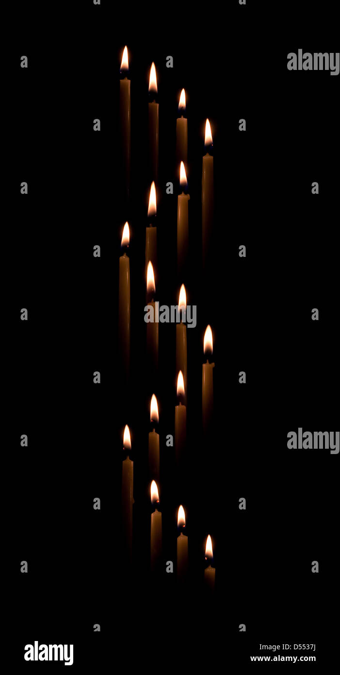 Gruppe von Spitzkerzen bilden eine Kerze Licht Spirale Grenze mit einem schwarzen Hintergrund Stockfoto