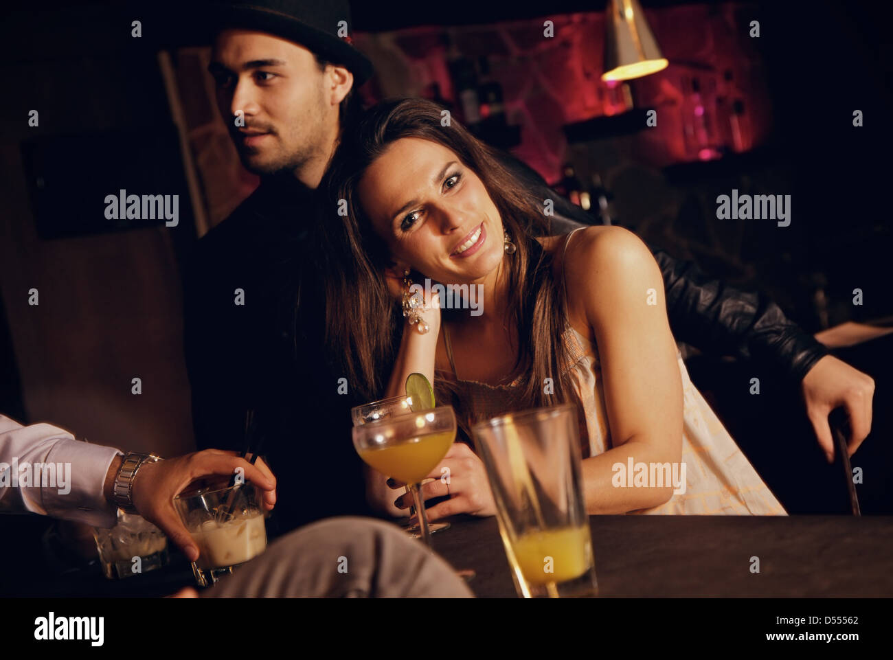 Lächelnde hübsche Frau an der Bar genießen Sie mit ihren Freunden Stockfoto
