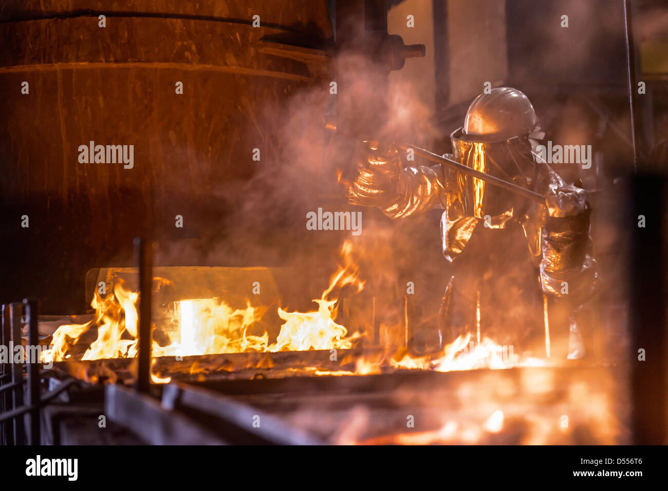 Arbeiter gießt geschmolzenes Metall in Fabrik Stockfoto