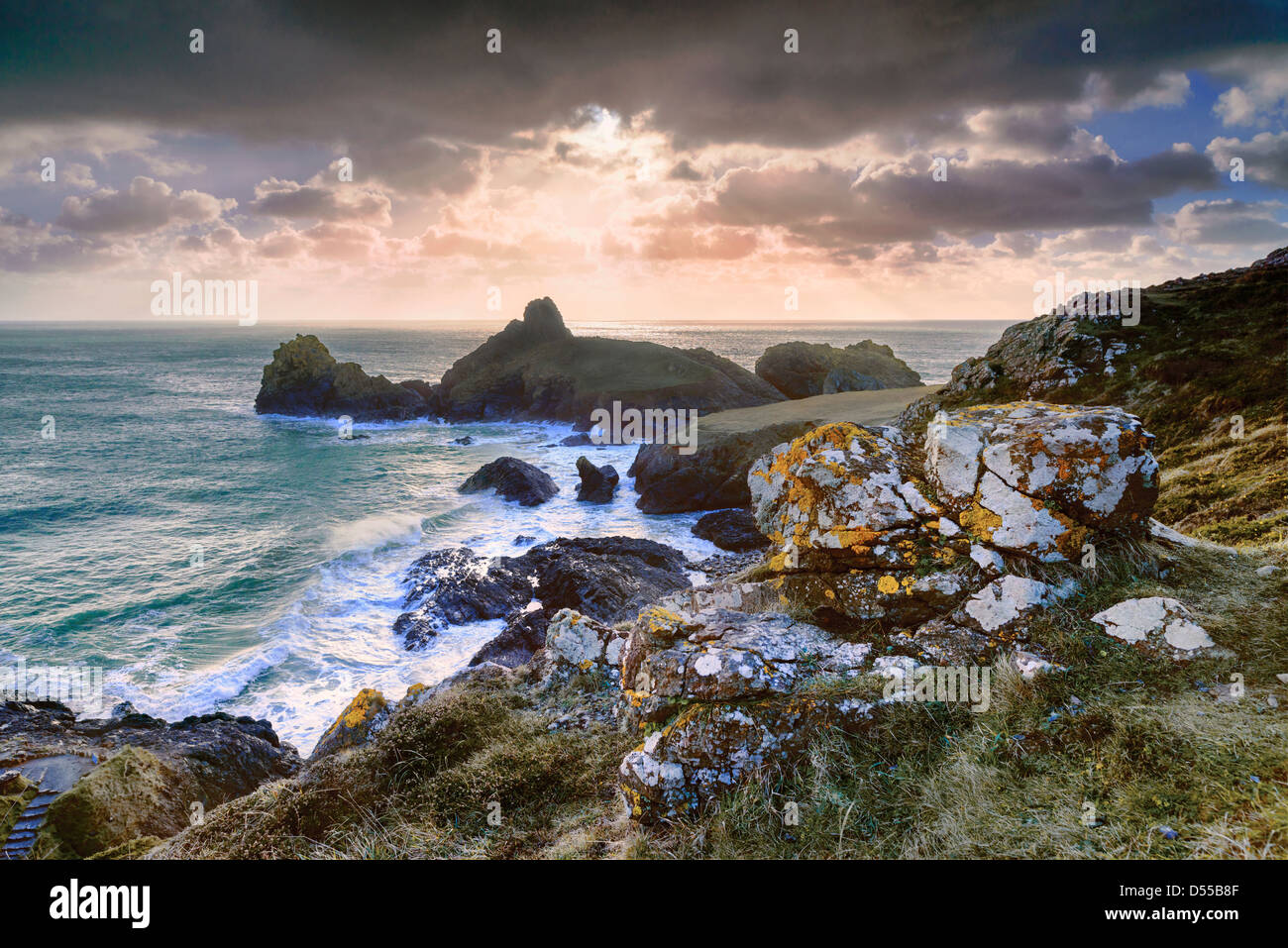 Sonne lugt hinter Regenwolken, die Erstellung von Sonnenstrahlen über Kynance Cove, Cornwall, England Stockfoto