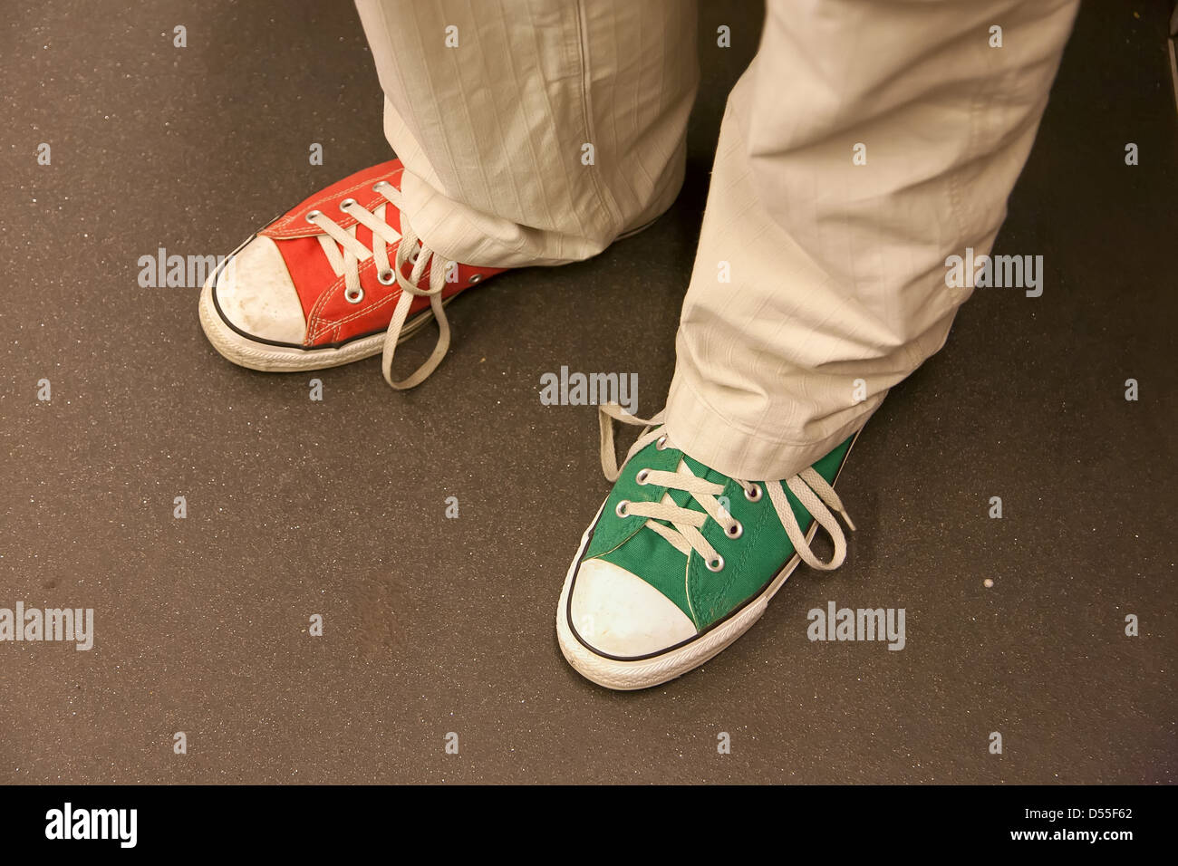 Berlin, Deutschland, der Mann mit der Marke Converse Sneakers in zwei  verschiedenen Farben Stockfotografie - Alamy