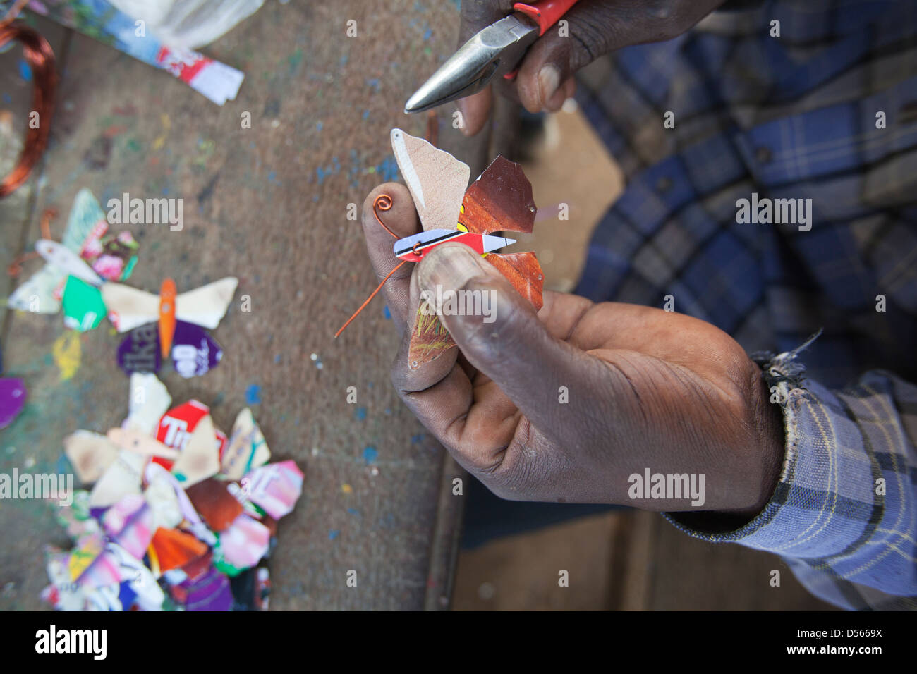Handwerkliche Herstellung eines Schmetterlings aus recyceltem Metall, Kisumu, Kenia. Stockfoto