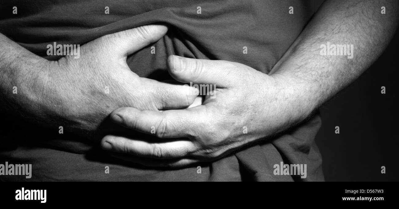 Mann hält seinen Bauch mit den Händen - krank und schmerzhaft Stockfoto