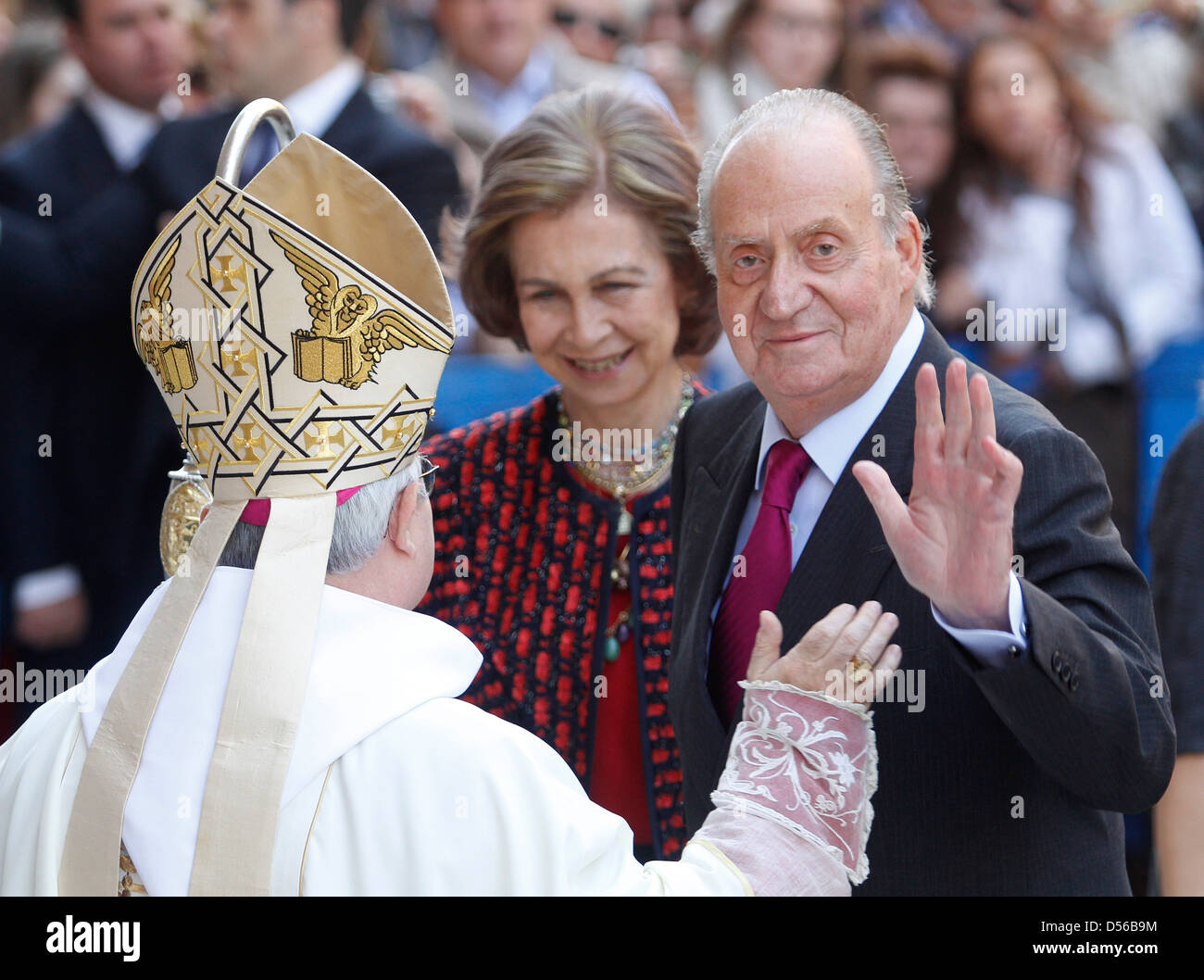 Spaniens König Juan Carlos (R) und Queen Sofia (C) treffen sich Palma de Mallorcas Bischof vor dem Besuch einer östlichen Sonntagsmesse. Stockfoto