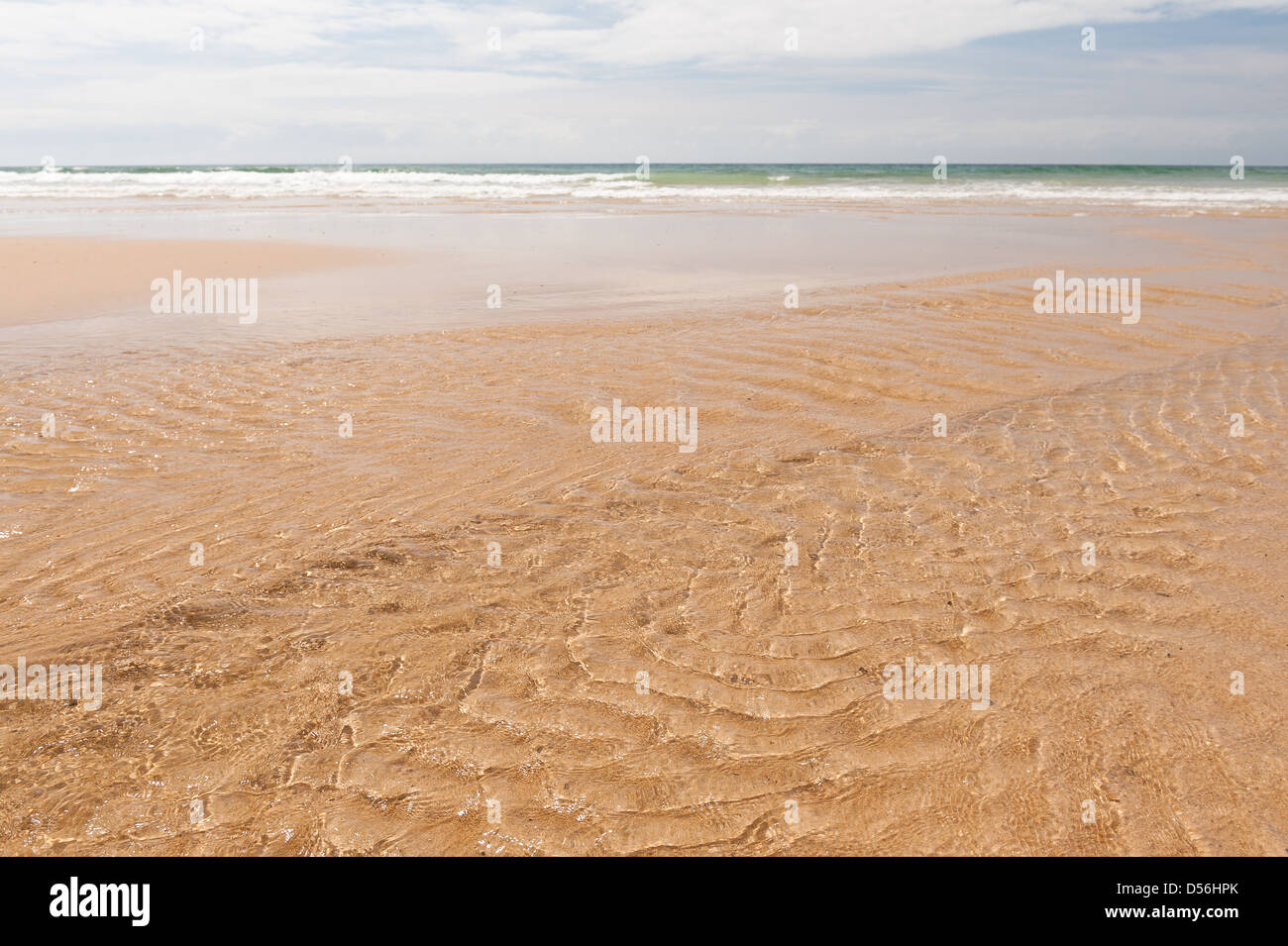 Ebbe Wellen Reflexionen Brechung streamen Wellenmuster im flachen Meerwasser, wie es Ablassen von Wasser aus Sandstrand läuft Stockfoto