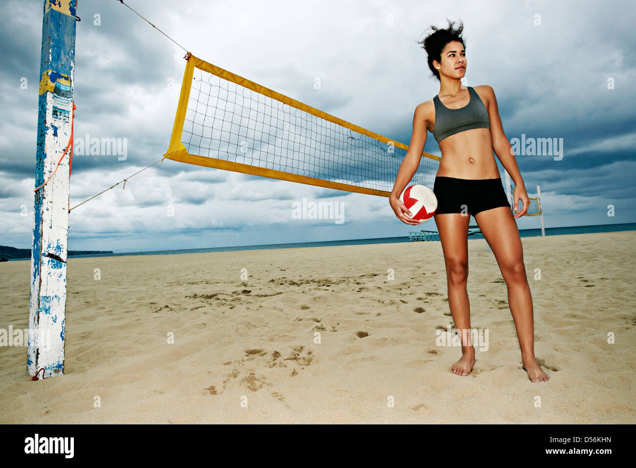 Gemischte Rassen Frau mit Beachvolleyball am Strand Stockfoto