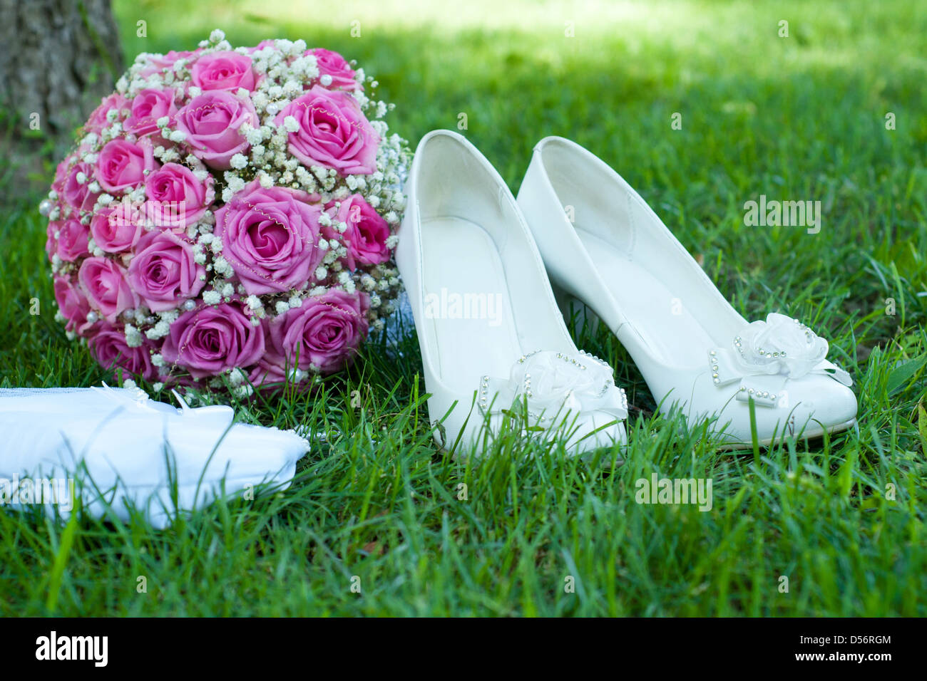 weiße Schuhe, rosa Strauß aus Rosen und eine schöne Handtasche der Braut  auf einem grünen Rasen Stockfotografie - Alamy