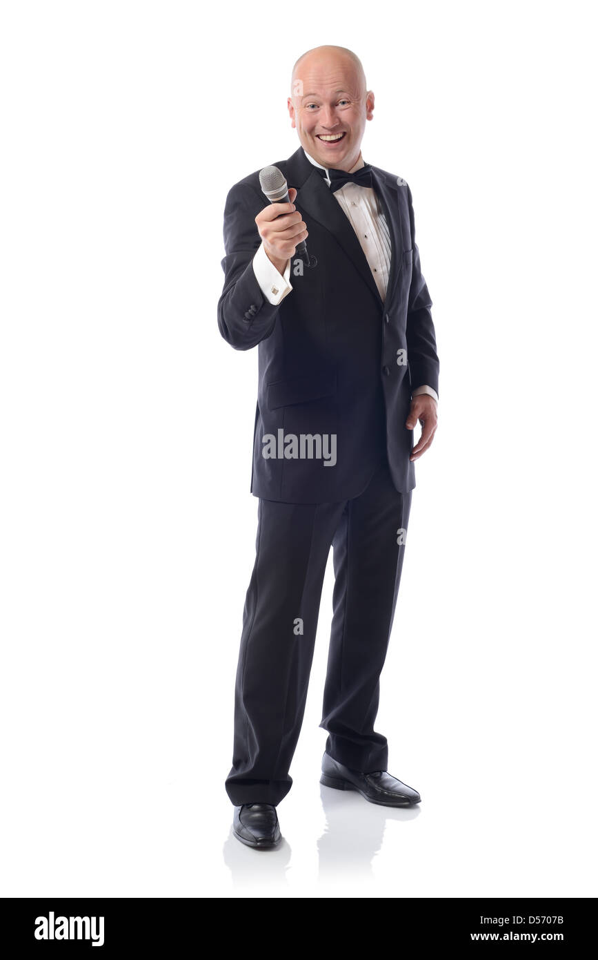 Mann in einem Smoking mit Mikrofon isoliert auf weiss Stockfoto
