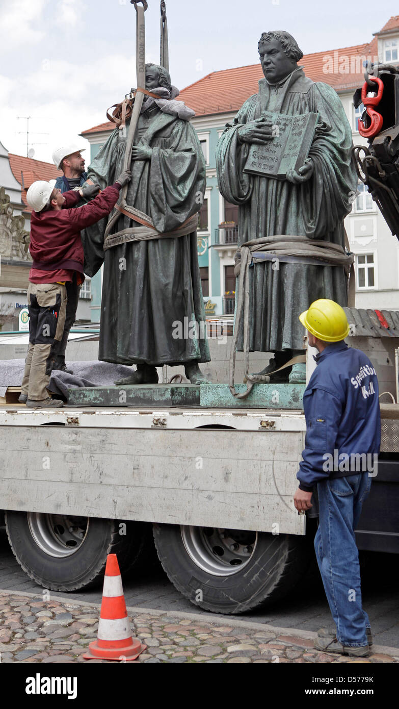 Ein Denkmal von Philipp Melanchthon (L) wird auf einen LKW neben ein Denkmal von Martin Luther in Wittenberg, Deutschland, 22. April 2010 geladen. Die Denkmäler des Reformators Luther (1483-1546) und seine Mitstreiter Melanchthon (1497-1560) werden für 1,2 Millionen Euro saniert werden. Beide Denkmäler werden am Reformationstag am 31. Oktober 2010 zurück. Bis dahin wird Künstler Ottmar Hoerl th füllen. Stockfoto