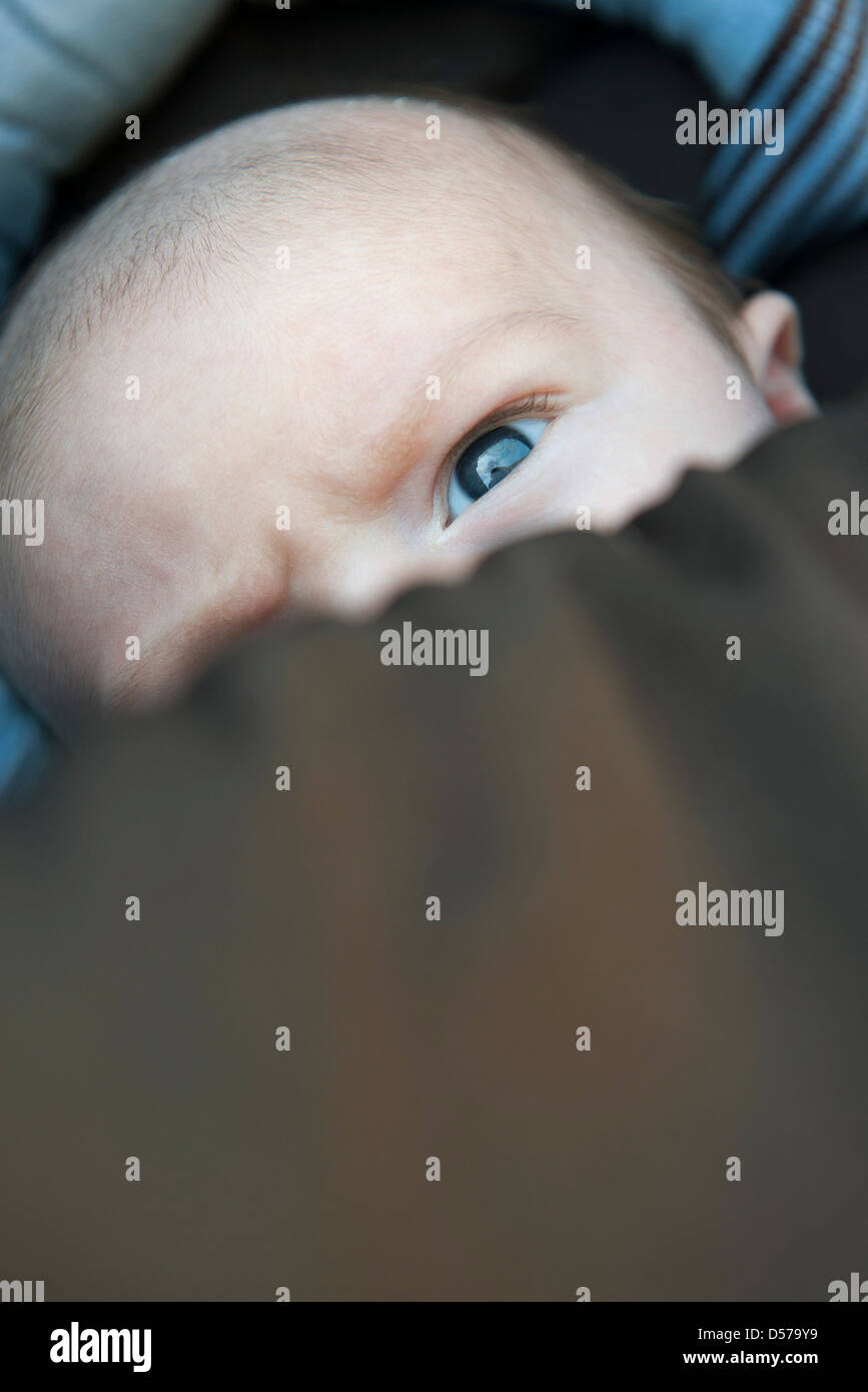 Baby mit Gesicht teilweise von Schneedecke bedeckt Stockfoto