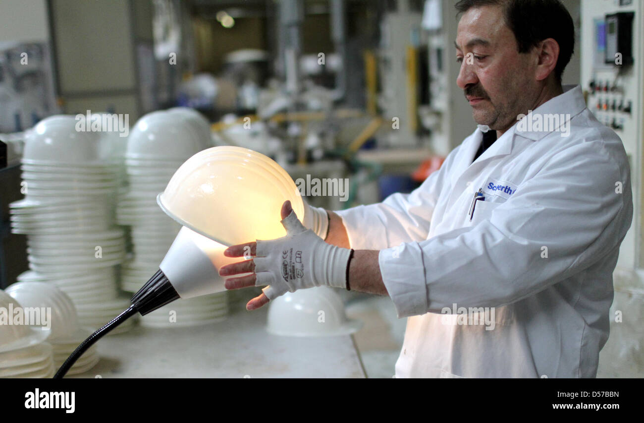 Sefik Yilmaz führt Endkontrolle auf einen Schutzhelm an der Produktionslinie der Schuberth GmbH in Magdeburg, Deutschland, 29. April 2010. Das Unternehmen wurde 1922 gegründet und produziert Motorrad Helme, Schutzhelme sowie speziell entwickelte Helme für Formel-1-Rennfahrer. Jedes Jahr werden einige 1,5 Millionen Helme von 350 Mitarbeitern produziert. Foto: Jens Wolf Stockfoto