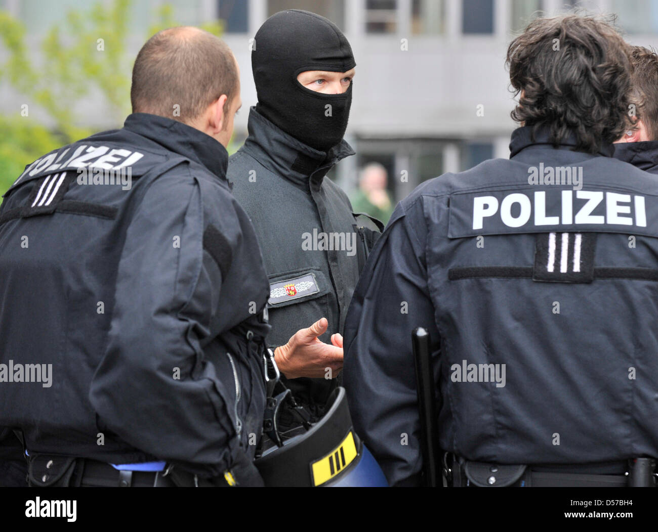 Mummed Offiziere des deutschen spezielle Polizei (SEK) sichern den Eintritt in einen Sicherheitsbereich, während der Angeklagte in das Gebäude am Bezirk Hof in Kaiserslautern, Deutschland, 4. Mai 2010 getrieben wird. Das Amtsgericht bekanntgeben, das Urteil über 4. Mai 2010 in einem Mordfall, in der zwei Männer der Motorrad Club "Hells Angels" wird vorgeworfen, der Chef der getötet haben '' Ou Stockfoto