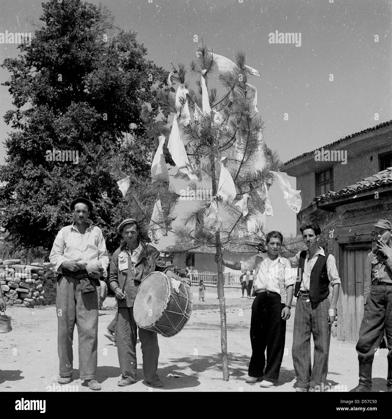 Bulgarien, 1950er Jahre. Historische Bild einer Gruppe von einheimischen Männer, mit einer Trommel stehen neben dem Baum mit Tischdecken auf. Stockfoto