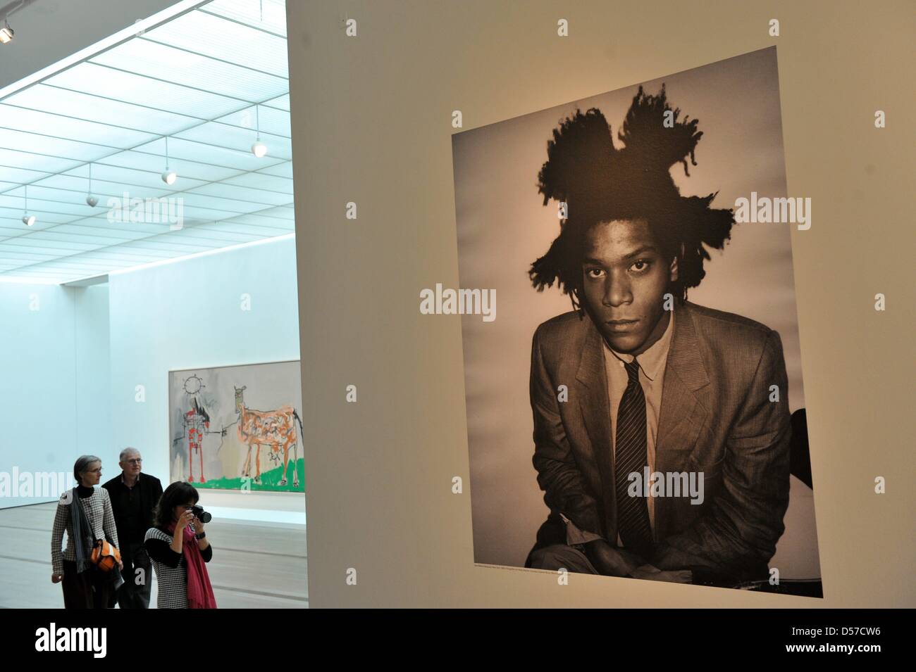 Besucher von der Presse-Preview der Ausstellung '' Basquiat'' vor einem Foto des Künstlers Jean-Michel Basquiaz am Museum der Fondation Beyeler in Riehen bei Basel, Schweiz, 7. Mai 2010 stehen. Auf der Occaision des 50. Geburtstages des 1988 verstorbenen Künstlers Jean-Michel Basquiet widmet die Fondation Beyeler eine große Retrospektive mit über 100 Gemälde, Papierarbeiten und ob Stockfoto