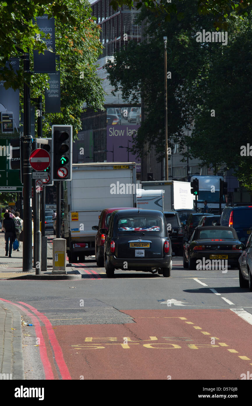Taxi und anderen Datenverkehr über eine grüne Ampel in der City of London, England. Stockfoto