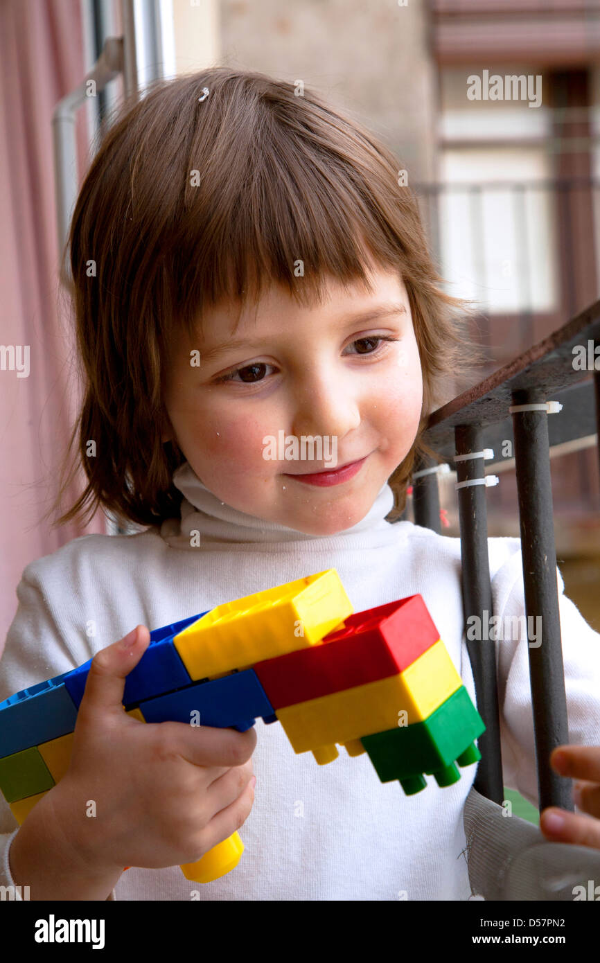 Gesunder vier Jahre alter Junge mit Pistole gemacht aus Legosteinen glauben machen. Stockfoto