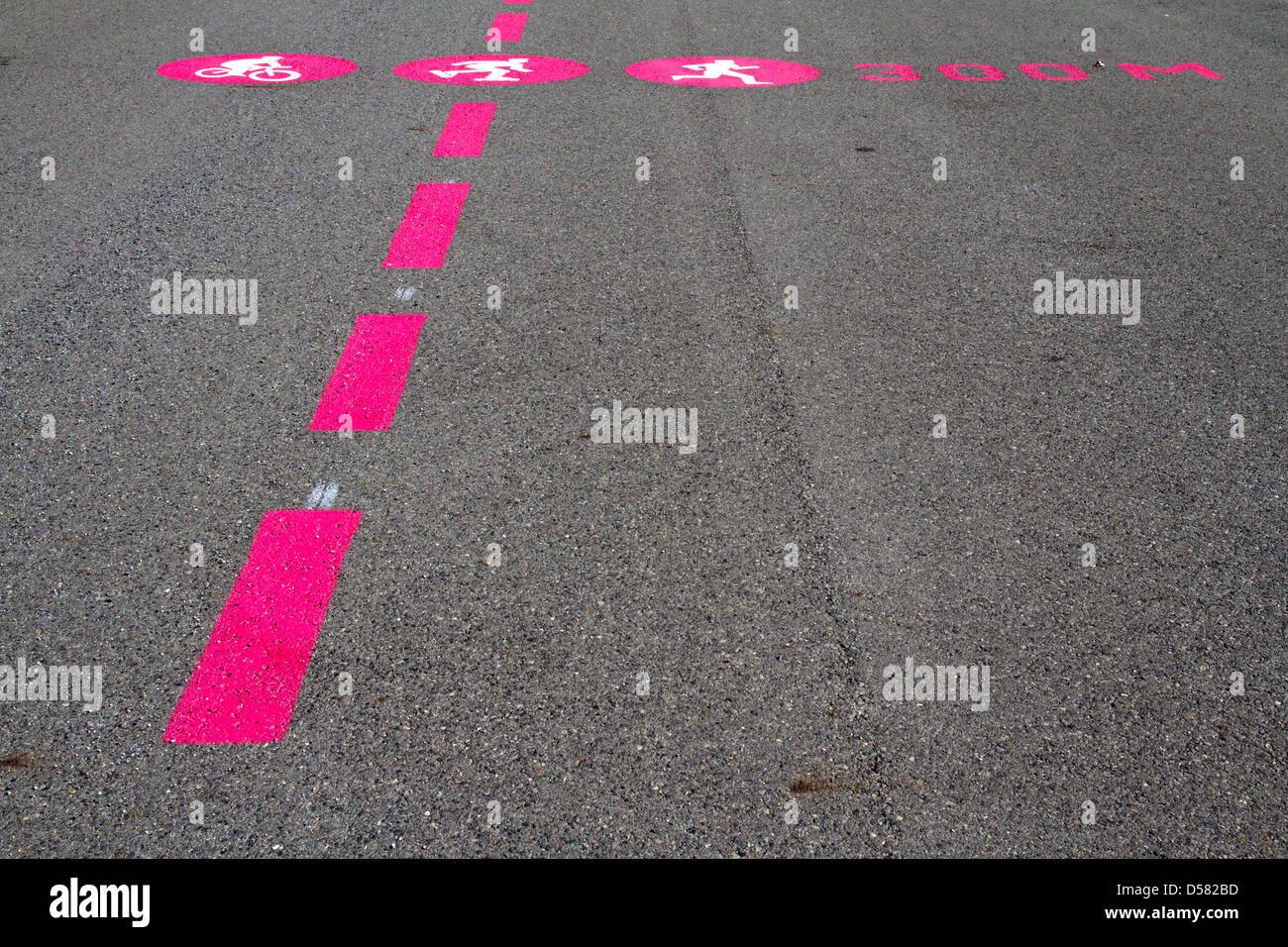 Piktogramme und Linien der Radfahrer, Fußgänger und Läufer auf einer rauen Asphalt-Oberfläche Stockfoto