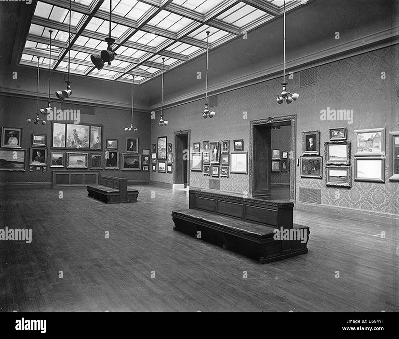Eine Fotografie der Ausstellungshalle der New Art Gallery in Montreal, Québec, aufgenommen 1913. Das Foto fängt das Innere der Galerie mit Kunstwerken in einer eleganten, ruhigen Umgebung ein. Stockfoto