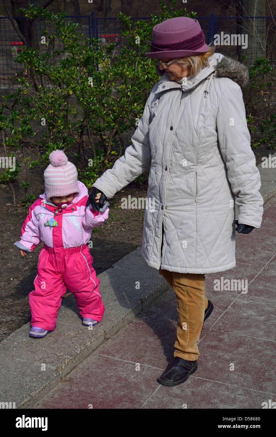 Großmutter Spaziergang mit ihrer kleinen Enkelin, 1 1/2 Jahre alt im park Stockfoto