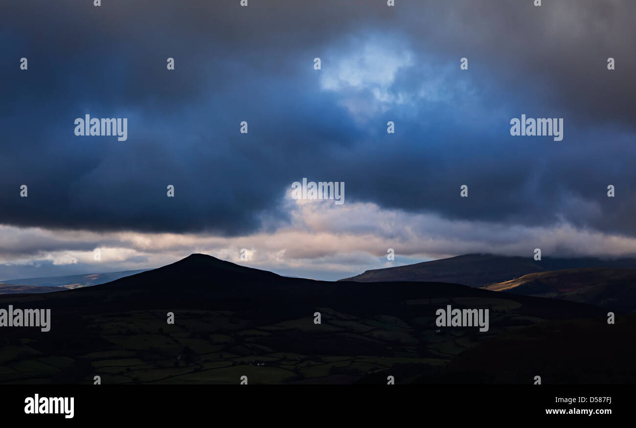 Gipfel des Zuckerhuts Silhouette mit dunklen Gewitterwolken, Wales, UK Stockfoto
