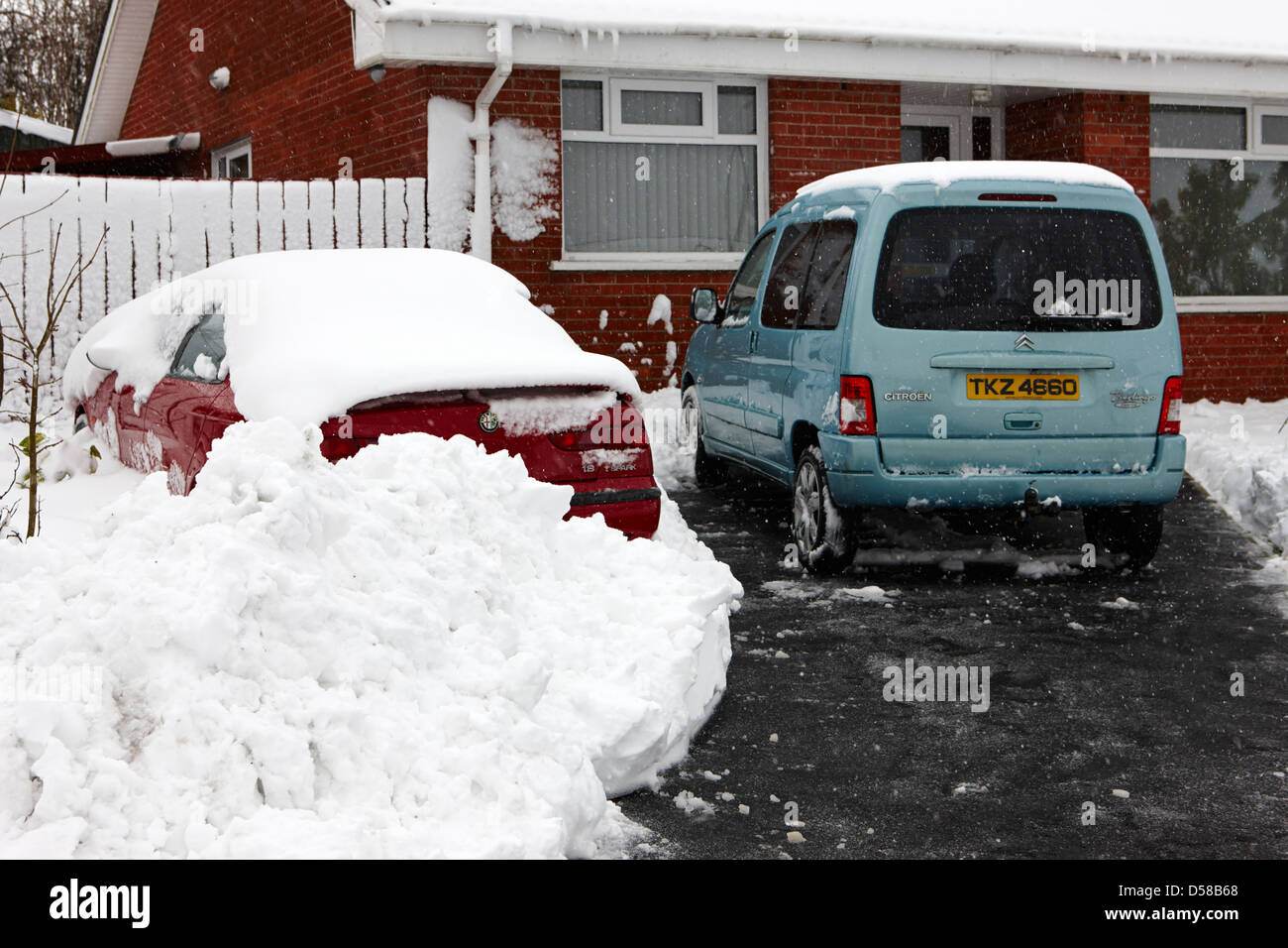 teilweise gerodeten Einfahrt vor Haus in schweren winter Schneesturm Herzinfarkt uk Stockfoto