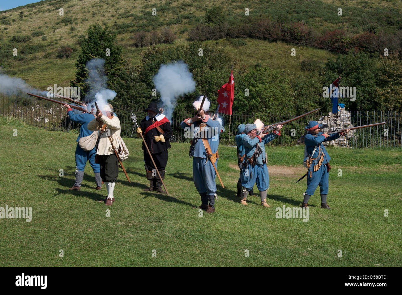Eine Gruppe von englischen Civil War Reenactor in den Uniformen der royalistischen Musketiere ihre Waffen abzufeuern. Corfe Castle in Dorset. England, Vereinigtes Königreich " Stockfoto