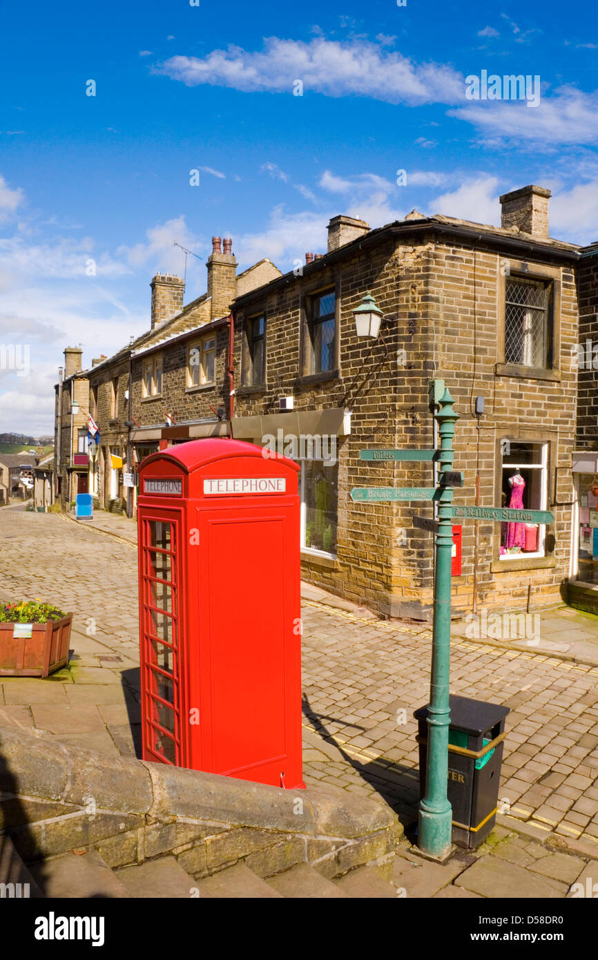 Rot Englisch Telefon Box und Reihenhäuser in das Dorf von Haworth in Yorkshire, Haus der Familie Bronte. Stockfoto