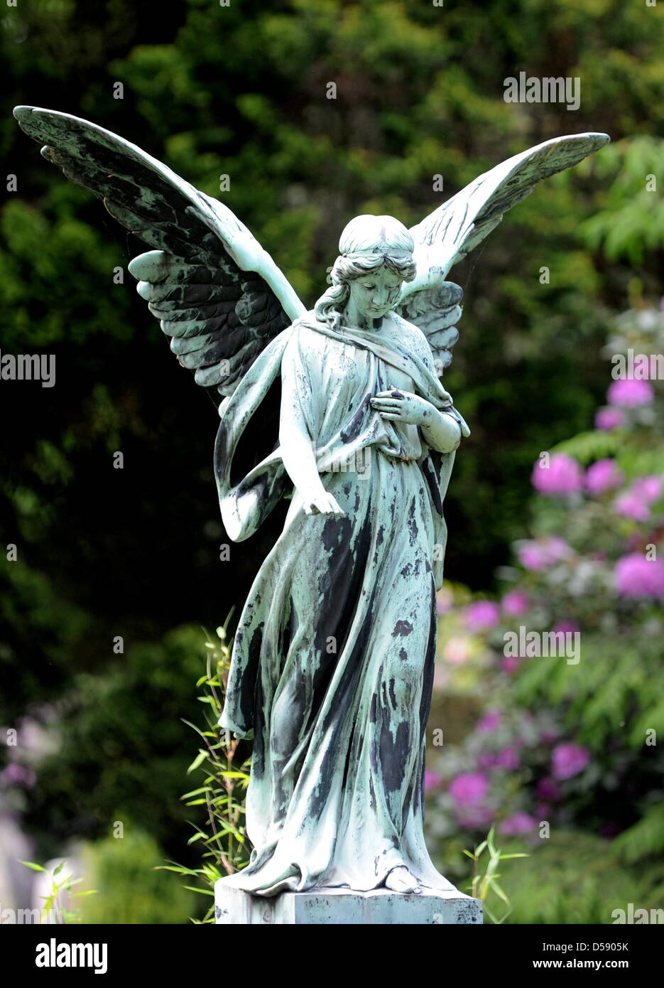 Eine Engelsfigur auf dem Ohlsdorfer Friedhof in Hamburg, Deutschland, 1. Juni 2010 abgebildet. Der Friedhof wurde als ein Landschaftspark von Wilhelm Cordes im Jahre 1877 auf 400 Hektar geplant. Zwei Buslinien bedienen auf 17 Kilometer auf dem Friedhof, der größte Grünfläche der Stadt ist. Bisher wurden einige 1,4 Millionen Beerdigungen. Foto: Maurizio Gambarini Stockfoto