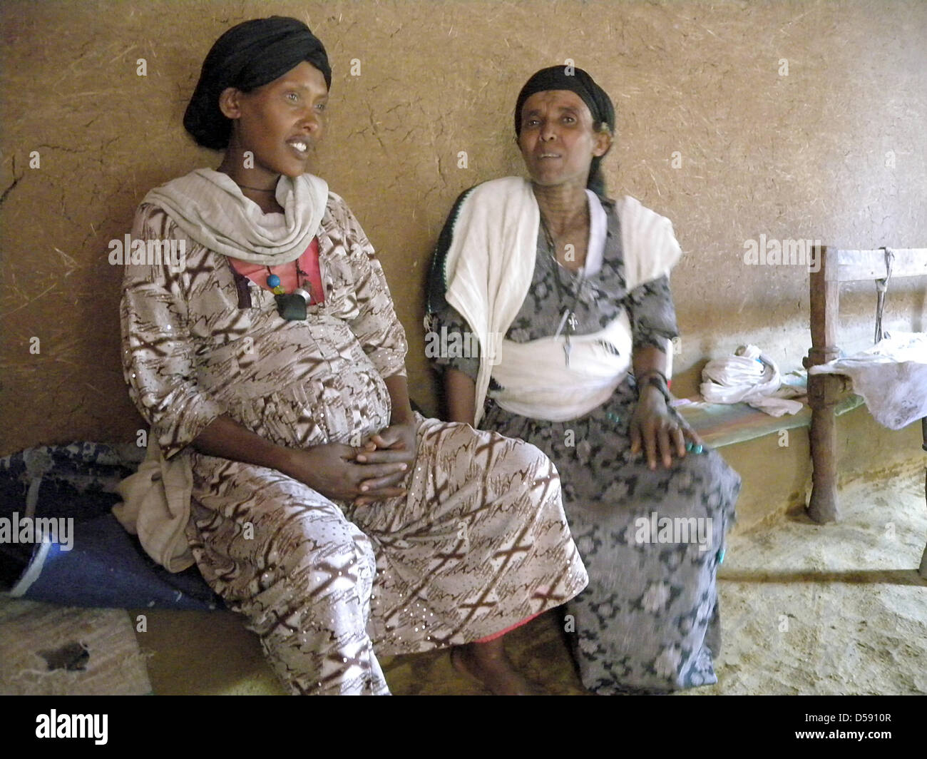 Die Hebamme sitzt Workenesh Habtamu (R) schwanger Zewee Tesfaye in ihrem Haus in Ambober, Äthiopien, 22. April 2010. Habtamu ist seit den letzten 25 Jahren Hebamme und in der Zwischenzeit kümmert sich die zweite Generation von Frauen, die sie dazu beigetragen, das Licht der Welt erblicken. Zusatzausbildung erhielt in Geburtshilfe sie von der Hilfsorganisation World Vision, die Unterstützung der pr Stockfoto