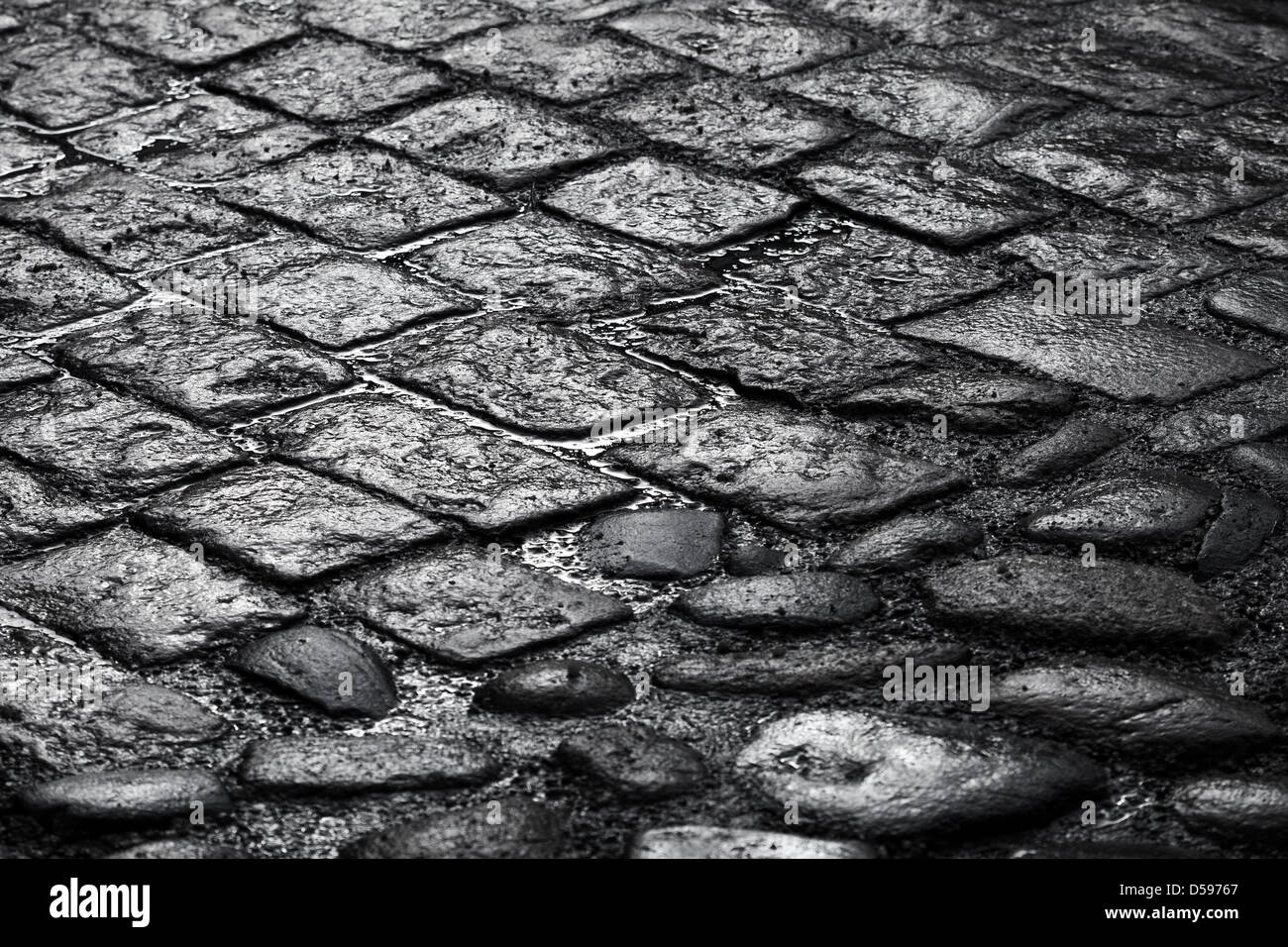 Closeup Hintergrundtextur nass der alten gepflasterten Straße Stockfoto