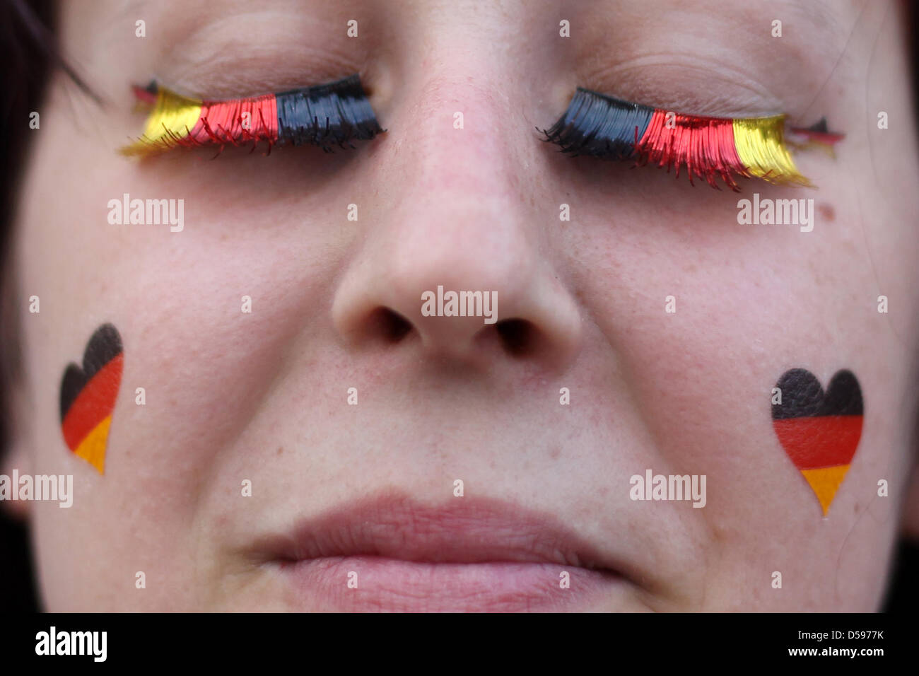 Mit Schwarz-Rot-goldenen Wimpern Und Aufgemahlten Herzen Auf Den Wangen Verfolgt Eine Zuschauerin bin Sonntag (13.06.2010) Auf der Wöhrder Wiese in Nürnberg (Mittelfranken) sterben Übertragung des Fußball-Weltmeisterschaftsspiels Deutschland - Australien. Foto: Daniel Karmann Dpa/lby Stockfoto