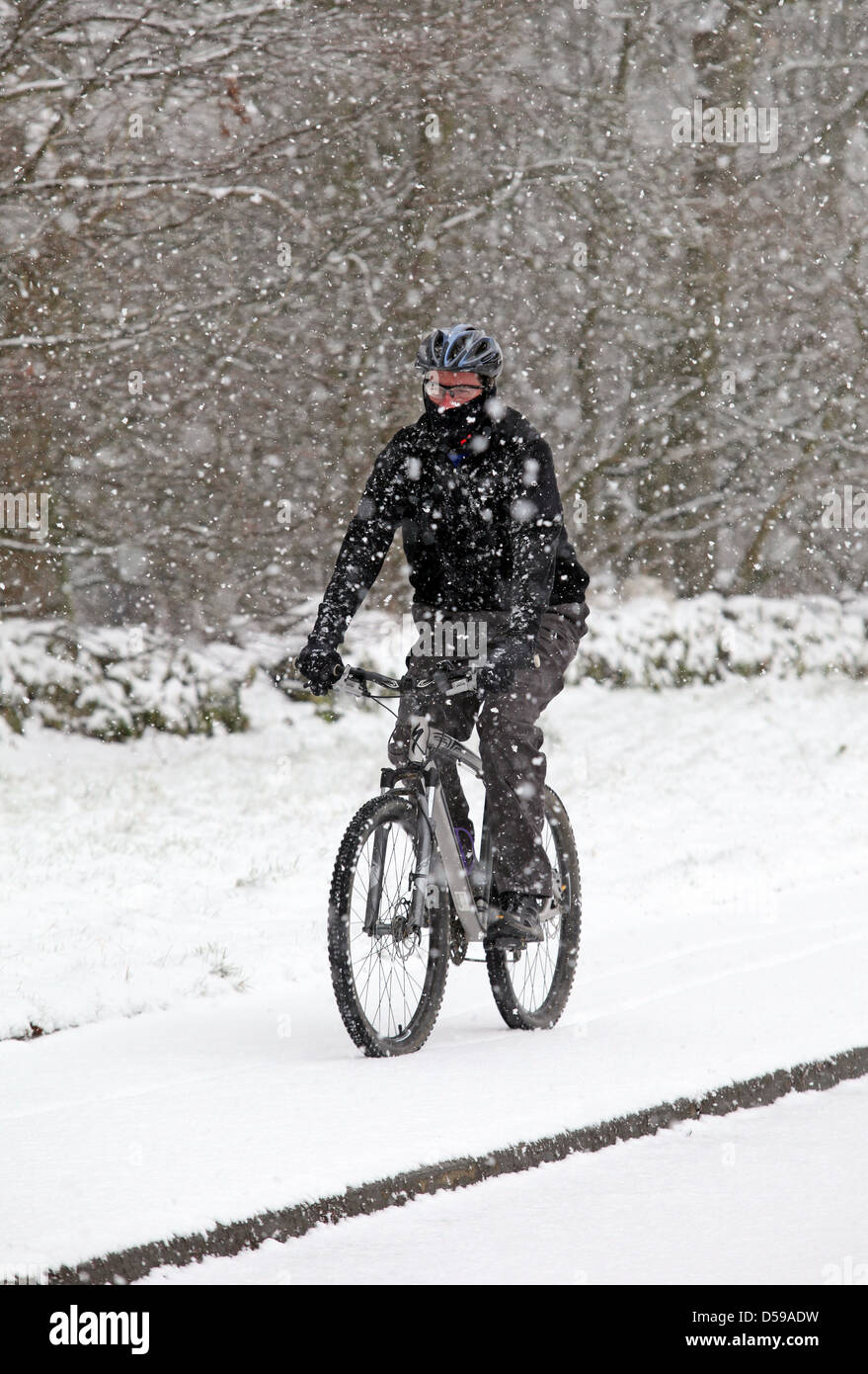 Radfahrer, Radfahren in starkem Schneefall während Schneesturm in Schottland im Vereinigten Königreich Stockfoto
