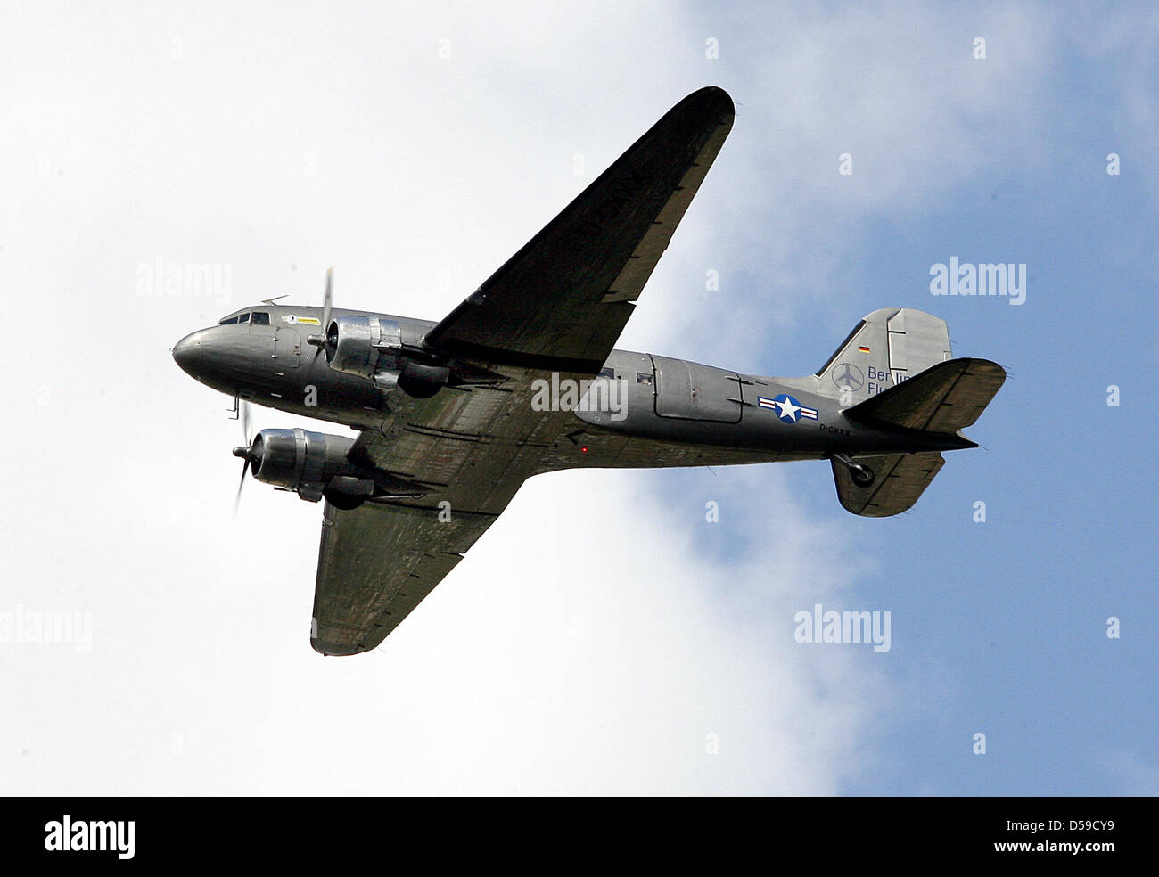 (Dpa-Datei) Ein Datei-Bild datiert 12. Mai 2009 von einer Douglas DC-3 Dakota über Berlin, Deutschland. Feuerwehrleute untersuchen einen abgestürzten Rosinenbomber, aka Candy Bomber auf einem Feld in der Nähe von Schönefeld, Deutschland, 19. Juni 2010. Vier der 25 Passagiere wurden bei der Notlandung verletzt. Das historische Flugzeug stürzte noch unsichere Gründen nach dem Abflug. Foto: Wolfgang Kumm Stockfoto