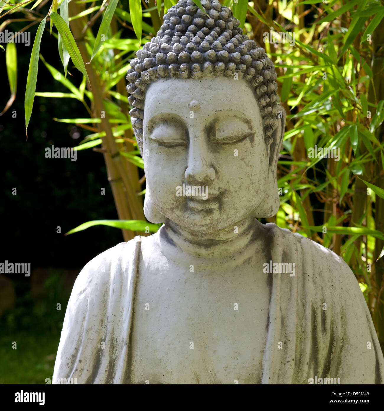 Buddha Skulptur mit Bambus Blätter im Hintergrund Stockfoto