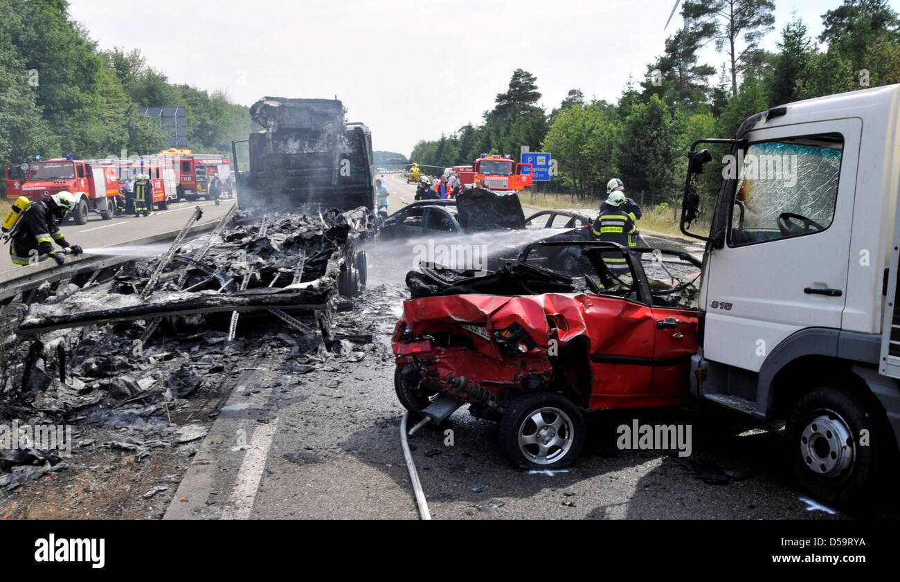 Feuerwehr löscht brennende Fahrzeuge auf der Autobahn 31 bei Dorsten, Deutschland, 2. Juli 2010. Eine mehrere Auto-Pile-Up zwei Menschen das Leben gekostet. Abgesehen von einem Warnschild, hatte ein LKW in das hintere Ende des Stau bei fast voller Geschwindigkeit schlug der Polizei gemeldet. Die Autos Ahed des LKW waren in oder übereinander geschoben. Zwei Personen verbrannte in ihren Fahrzeugen. A Stockfoto