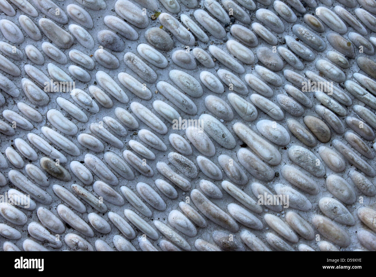 Kleine graue Kieselsteine Steinmauer für Hintergrund. Stockfoto