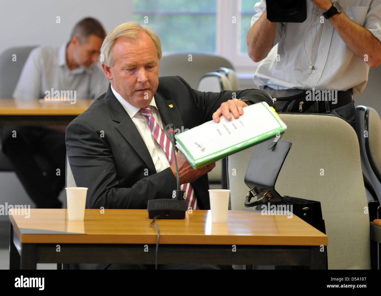 Der amtierende Gouverneur von Kärnten, Gerhard Doerfler, packt seine Ordner am Anfang des Board of Anfrage Anhörung über die BayernLB-Bank an der Baverian Landtag in München, 9. Juli 2010. Der Vorstand der Anfrage befasst sich mit der Klärung der Fehlkauf von der Kärntner Bank Hypo Group Alpe Adria (HGAA) durch die Bayerische Landesbank BayernLB, milliardenschwere Stockfoto
