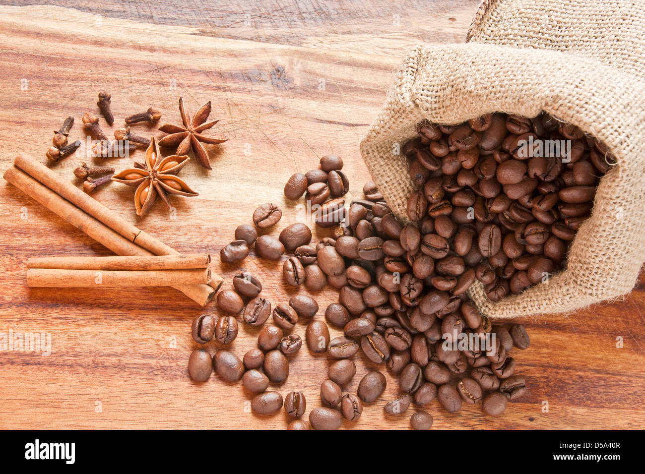 Kaffeebohnen in Cack, Cinnamone Rinde, Nelken und Sternanis auf Holz Schreibtisch Stockfoto