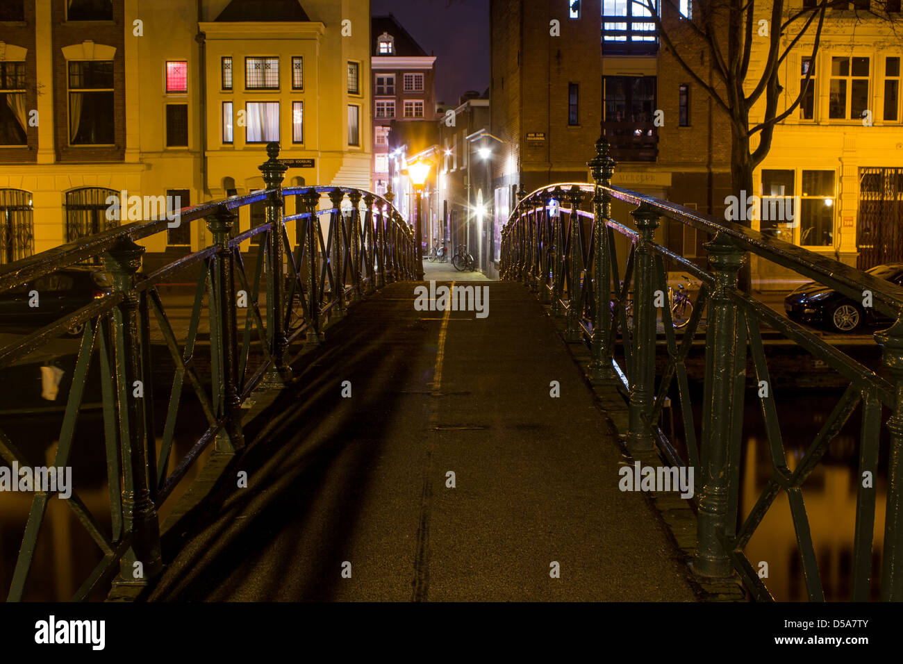 Amsterdamer Gracht mit Fußgängerbrücke in der Nacht Stockfoto