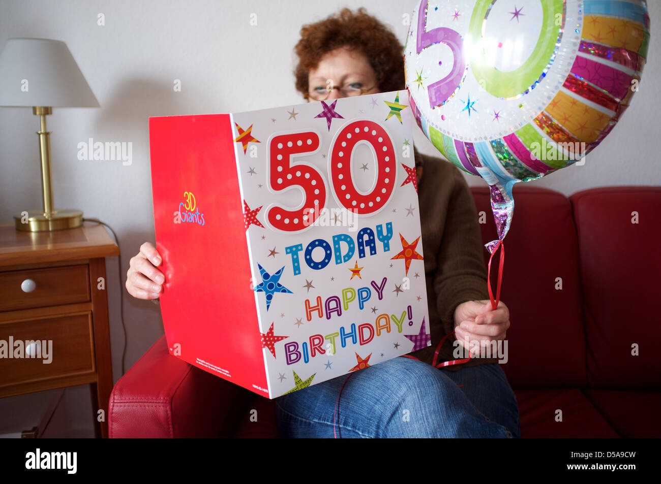 Eine Frau zu Hause feiern allein ihren 50. Geburtstag Stockfoto