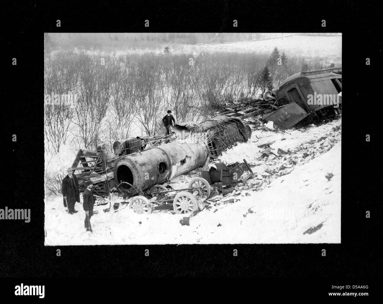 Ein Foto, das einen Eisenbahnunfall mit Motor 70 zeigt, verursacht durch eine Kesselexplosion, mit dem Wrack in einer Schneebank. Dieses Bild ist Teil des Archivs der Cornell University Library über Eisenbahnunfälle. Stockfoto