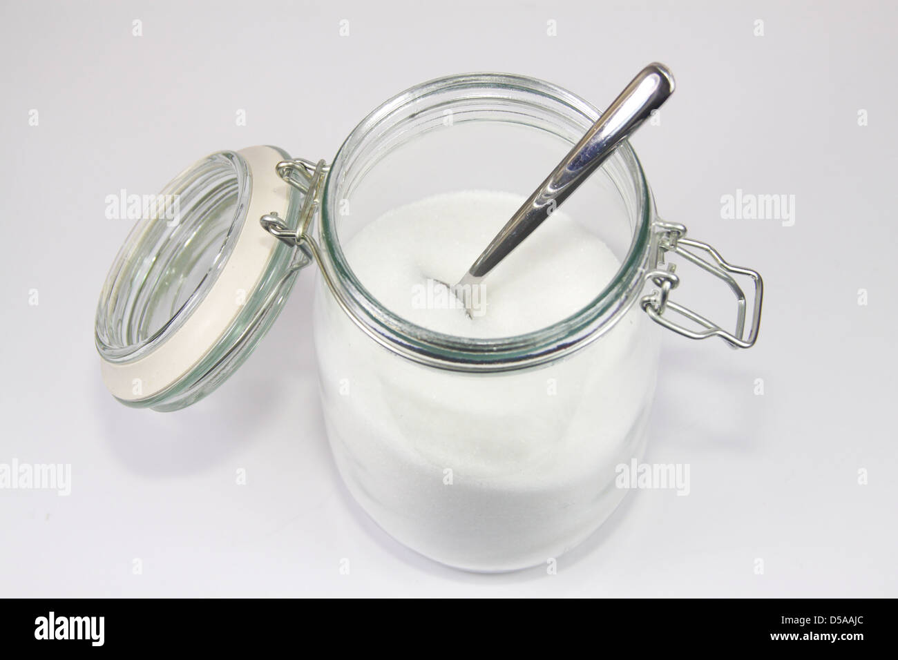 Glas Vorratsgefäß Weißzucker zu öffnen, mit Löffel Stockfoto