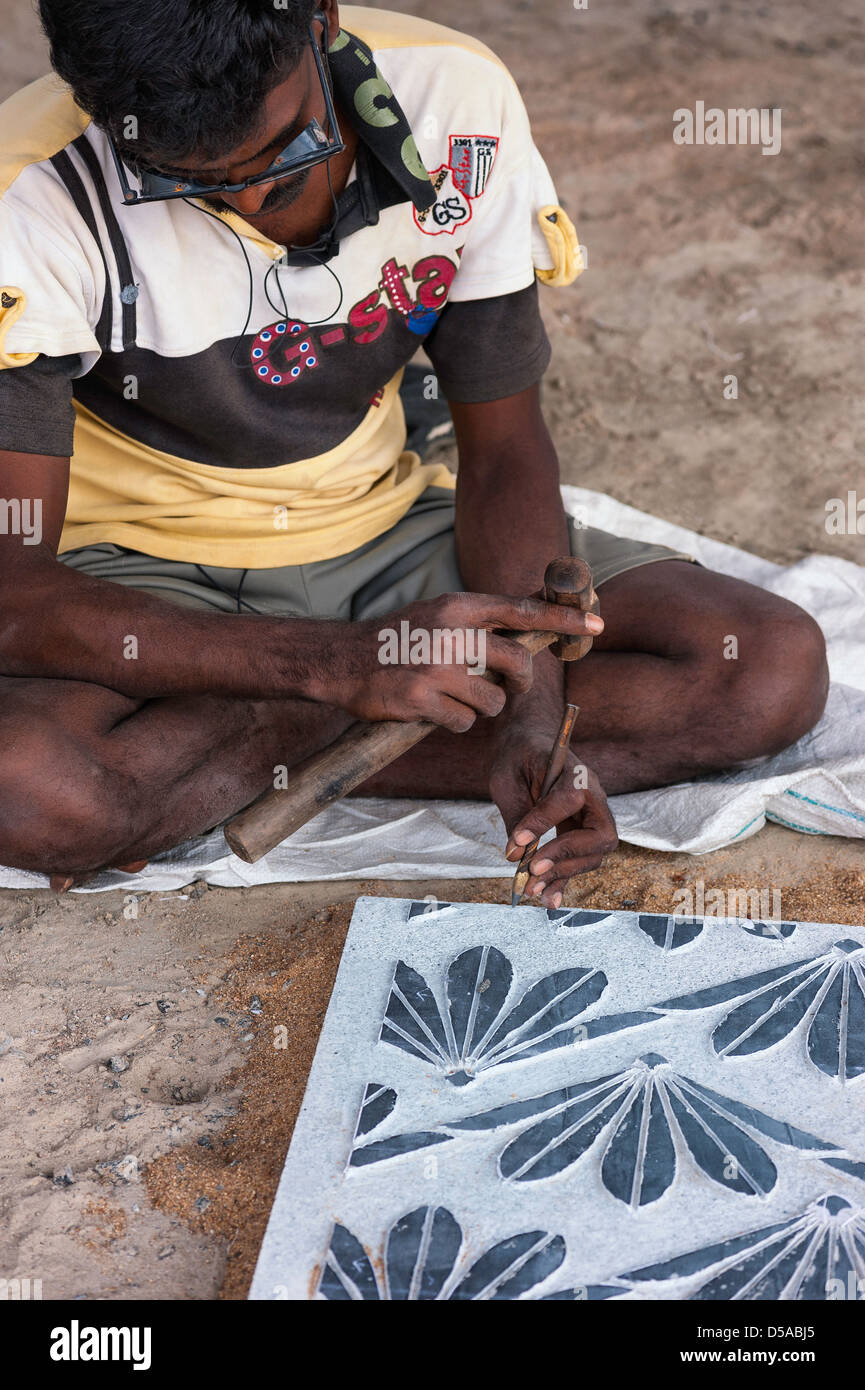 Bildhauer bei der Arbeit auf einem Stück Granit im Anschluss an alten Tamil Tradition in Mamallapuram, Tamil Nadu, Indien. Stockfoto