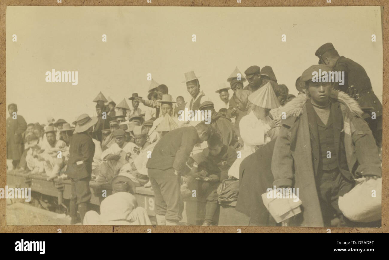 Ein Foto eines japanischen Soldaten mit koreanischen Passagieren an Bord eines Zuges. Das Bild zeigt die militärische Präsenz und die Rolle von Zügen im Kriegsverkehr während der japanischen Besetzung Koreas. Stockfoto