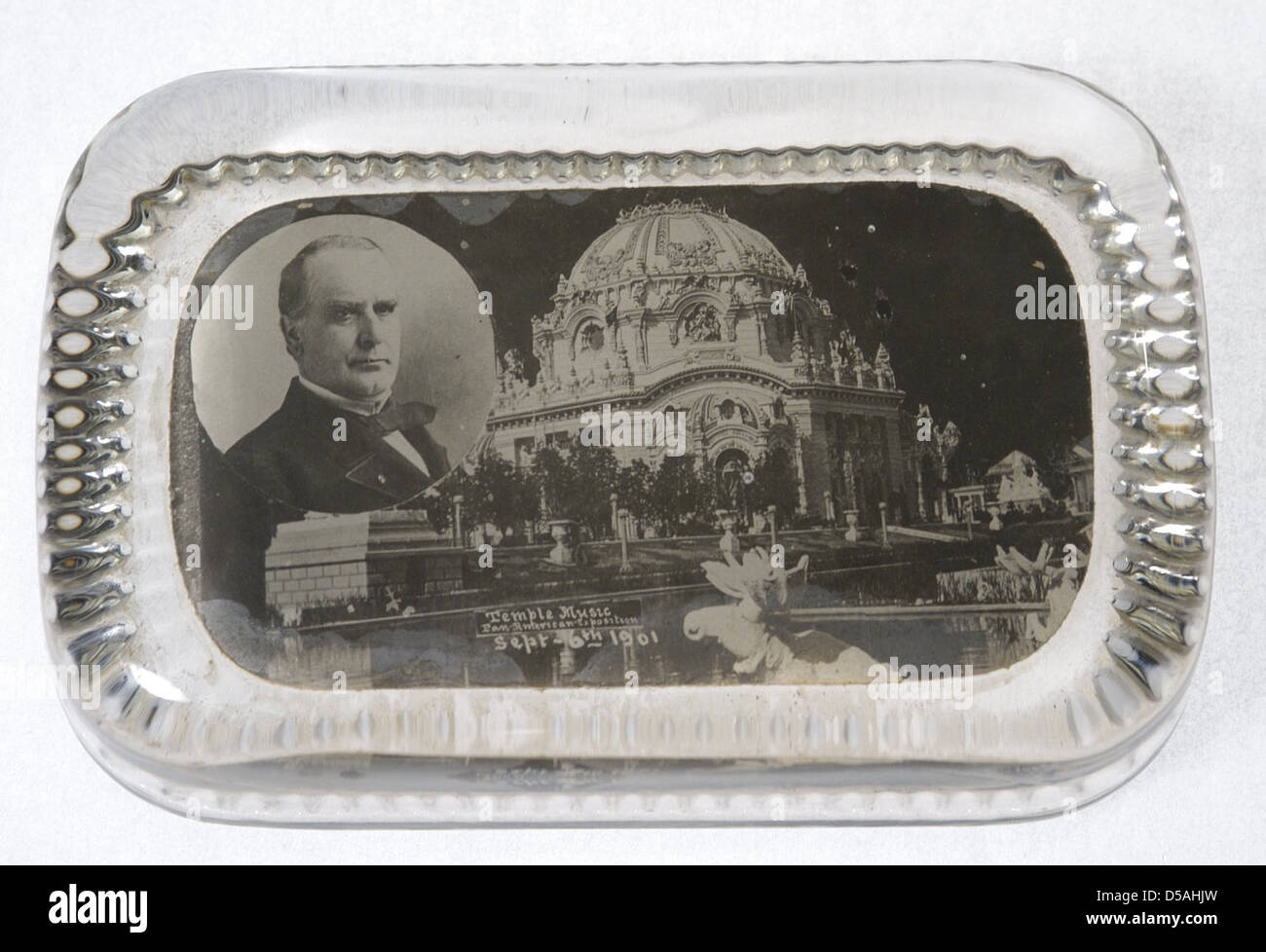 Dieser Briefbeschwerer erinnert an die Ermordung von Präsident William McKinley im Temple of Music während der Panamerikanischen Ausstellung 1901 in Buffalo, New York. Das Stück zeigt eine Büste von McKinley und ist mit der Trauerkultur dieser Zeit verbunden. Es spiegelt das tragische Ereignis wider, das sich im Tempel der Musik ereignete, einem bedeutenden Gebäude der Ausstellung. Stockfoto