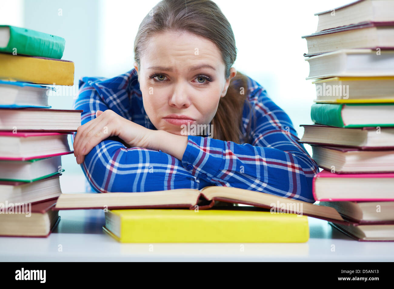 Porträt eines frustrierten Studenten mit Stapeln von Büchern umgeben zu sein Stockfoto