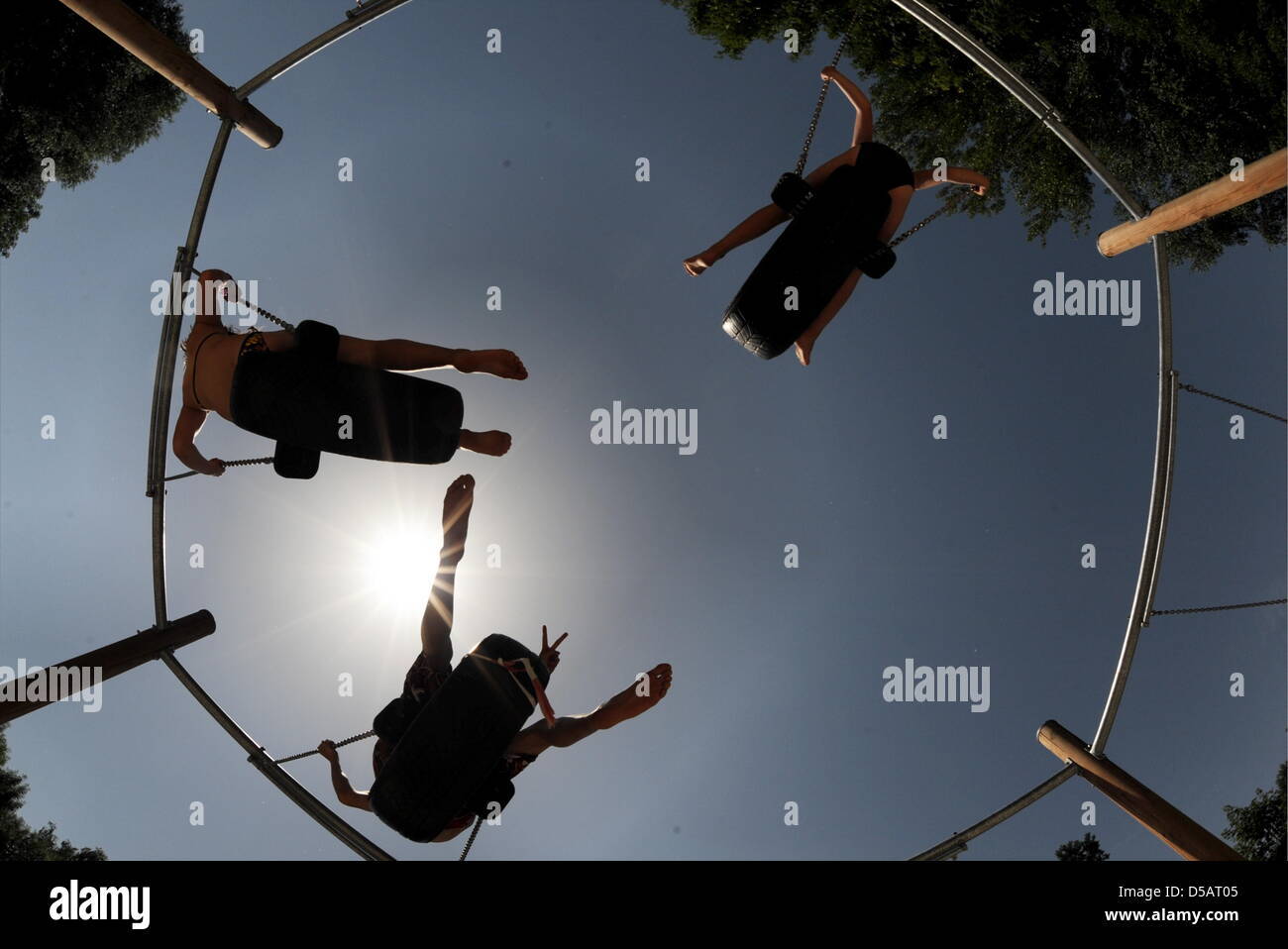 Jugendliche wiegen auf Schaukeln am Feldmoching See in München, Deutschland, 10. Juli 2010. Am gleichen Wochenende war das Wetter in ganz Deutschland anhaltend Suny bei Temperaturen von über 30 Grad Celsius. Foto: Tobias Hase Stockfoto