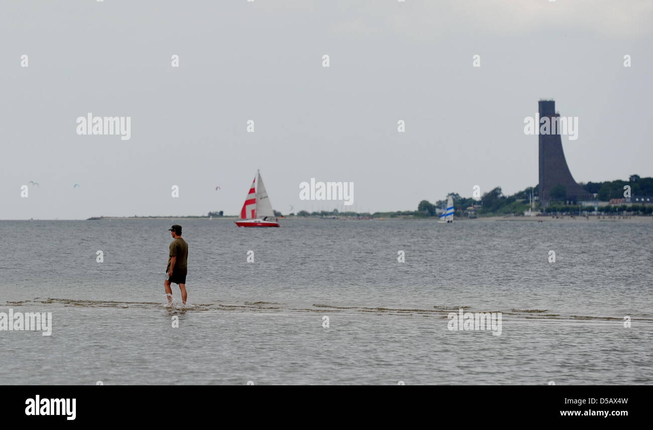 Ein Mann geht für einen Spaziergang an der Kieler Förde am Ufer der Ostsee, hinter ihm das Marine-Ehrenmal in Laboe, Deutschland, Bild, aufgenommen am 13. Juli 2010 gesehen werden kann. Nach Luftdruck Stürme die Temperaturen bis 31 Grad Celsius gesunken. Foto: Angelika Warmuth Stockfoto