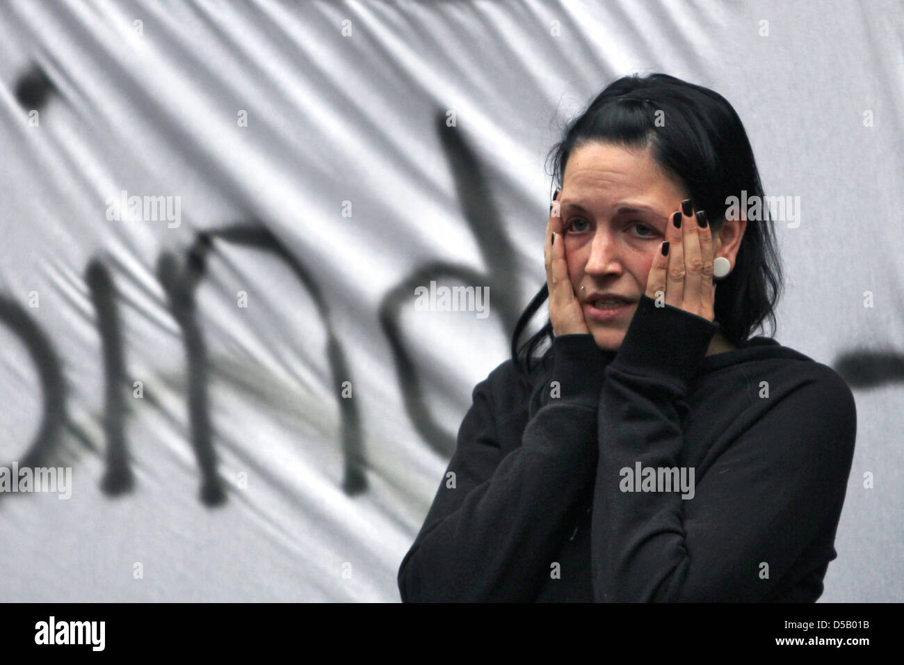 Eine Frau drückt ihre Hände auf ihren Kopf während einer Demonstration für die Opfer der Love Parade vor dem Rathaus in Duisburg, 29. Juli 2010. 200 Menschen forderte Bürgermeister Sauerland Rücktritt und die Opfer in einer Schweigeminute gedacht. Am 24. Juli 2010 21 Menschen starben und Hunderte von Menschen wurden verletzt, während eine Massenpanik bei Techno-Musik-Festival Liebe Parad Stockfoto