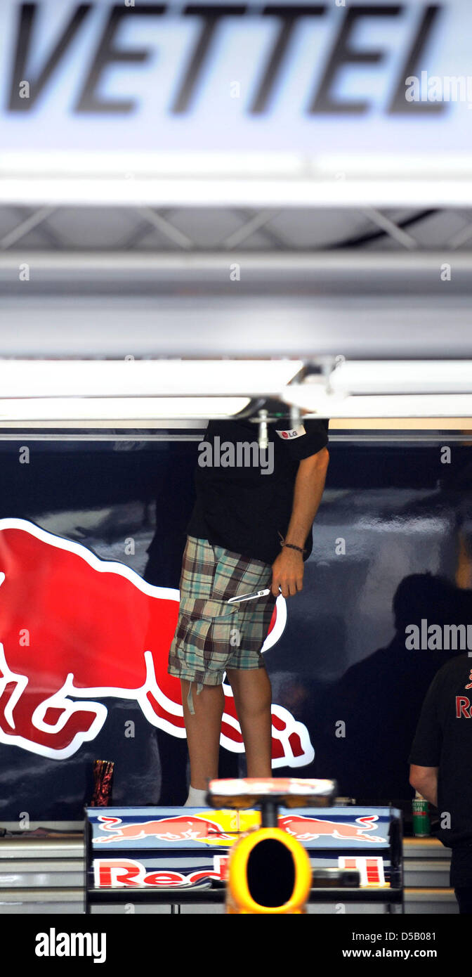 Der deutsche Formel1 Rennfahrer Sebastian Vettel von Red Bull arbeitet an einer Deckenkonstruktion, stehend auf einem Tisch, in der Grube auf Hungaroring Rennstrecke in der Nähe Budapest, Ungarn, 29. Juli 2010. Die Ungarn Grand Prix statt findet am 1. August als das zwölfte Rennen der Formel-1-Saison 2010. Foto: Peter Steffen Stockfoto